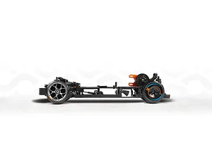 Side view of an RC drift car chassis showing the frame, suspension, gears, and wheels against a white studio background.