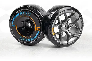 Two RC drift car wheels with slick black rubber tires and custom spoke designs against a light background.