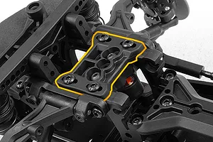Close-up of black plastic RC car chassis components with an orange highlighted upper deck plate.