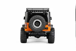 Rear view of the RGT Rock Cruiser Evolution V3 1/10 scale RC rock crawler, featuring an orange and black body with a spare tire mounted on the back.