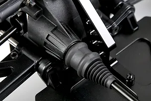 Close-up view of the RC buggy drive shaft boot and differential housing, showing durable plastic and metal construction.