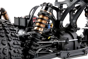 Close up view of the black and bronze colored suspension shock absorber on a Rovan RC buggy chassis.