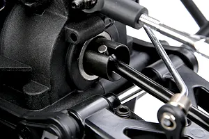 Close-up studio view of the rear differential outdrive, driveshaft, and suspension components on an RC vehicle chassis.