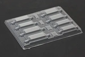Uncut clear polycarbonate intercooler set sheet for RC body shells on a dark surface.