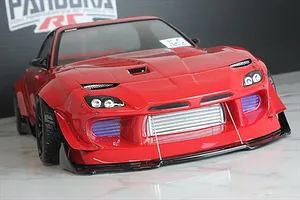 Front view of a red RC drift car body showing an installed intercooler accessory behind the front bumper opening.
