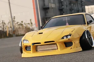 Front view of a yellow RC drift car body shell outdoors with a visible intercooler installed in the front bumper.