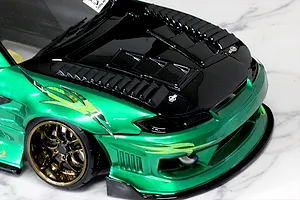 Close-up of a custom green and black RC drift car body installed with aerodynamic duct parts and vents on the hood.