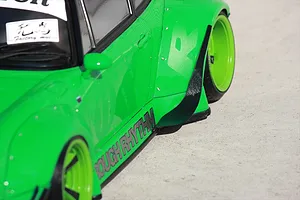 Close-up of a bright green RC car body featuring wide fender flares, black side skirts, and custom wheels.