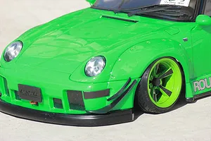 Close-up of the bright green RWB wide fender set fitted to a model RC car body shell, showing front wheel and bumper details.