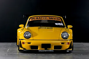 Front view of a yellow Pandora RC RWB 993 type body shell with wide fenders, front spoiler, and RAUCH-Welt windshield banner.