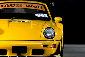 Close-up front angle of a yellow Pandora RC RWB 993 Type body shell showcasing the headlight, bumper, and windshield banner.