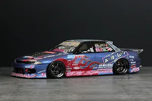 A fully painted and decaled Pandora RC Nissan Skyline R32 4-door drift RC body shell mounted on a chassis against a dark background.
