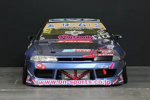 Front view of a blue custom painted RC drift car body shell, featuring decals, an intercooler, and a lowered stance.