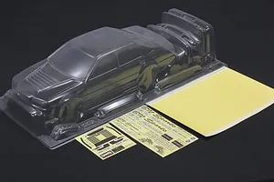 Unpainted clear polycarbonate RC car body shell with separate parts, decal sheets, and window masks on a dark surface.