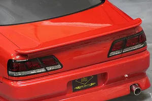 Close-up view of the rear of a red Toyota Cresta JZX100 RC drift car body showing tail lights, spoiler, and exhaust tip.