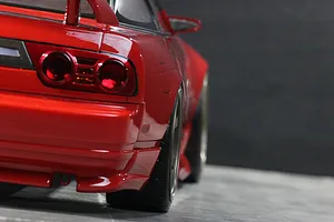 Close-up rear angle view of a red RC drift car body shell showing taillights, rear bumper, and wide wheels.