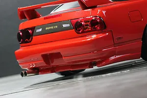 Close up of the rear end of a red Pandora RC RPS13 180SX Kouki drift car body shell, showing taillights and dual exhaust tips.