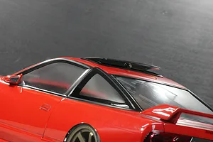 Close-up of the red roof, rear window, spoiler, and open sunroof on a Pandora RC RPS13 180SX Kouki body shell.