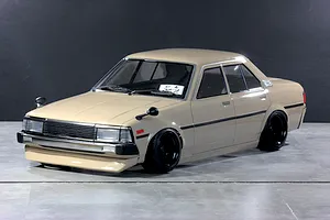 Tan Pandora RC Toyota Corolla KE70 RC drift car body shell mounted on a chassis with black wheels.