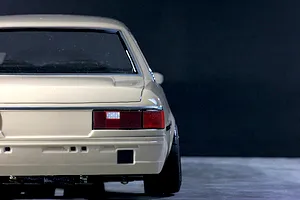 Rear view of a beige Toyota Corolla KE70 RC drift car body shell displayed against a dark studio background.