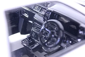 Close-up of a detailed black RC car interior set installed in a model body, showing the dashboard and steering wheel.