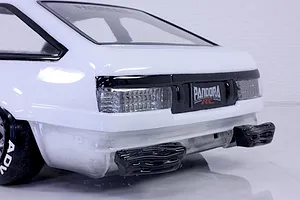 Close-up of the rear end of a white RC car body showing detailed tail lights and custom bumper inserts against a white studio background.