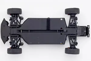 Top down view of the black plastic chassis of the Kyosho Fazer Mk2 RC car featuring suspension arms, wheels, and battery strap.