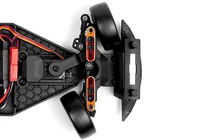 Top down close up view of the front chassis and steering assembly of an RC car showing black plastic parts, orange accents, and black wheels on a white background.