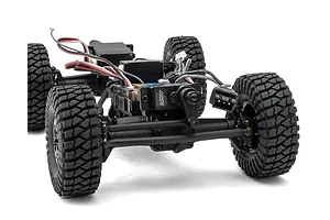 Close-up front view of the chassis, steering servo, electronics, and rubber tires of a 1/24 scale RC rock crawler.