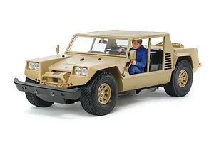 Tamiya XR311 combat support vehicle RC car in desert tan with a driver figure, shot against a white background.