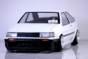 Front three-quarter view of a white Pandora RC Toyota AE86 Corolla Levin 2DR model car on a reflective surface.