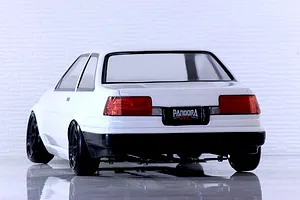 Rear view of a white Pandora RC Toyota AE86 Corolla Levin 2-door RC car body on a reflective white surface.