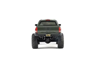 Rear view of the green Axial Toyota Tacoma RC rock crawler showing scale details, oversized tires, and license plate against a white background.