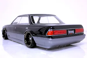 Rear three-quarter view of a painted Pandora RC Toyota Mark 2 JZX81 body shell in black and grey on a white surface.