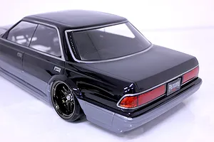 Rear three-quarter studio view of a black and silver RC drift car body shell with detailed tail lights and custom wheels.