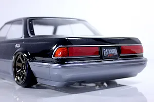 Rear quarter angle view of a black and silver RC drift car body shell showing tail lights and rear wheel.