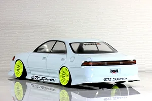 Rear three-quarter view of a white Toyota Mark II JZX90 RC drift car body shell with bright yellow wheels and BN Sports decals.