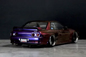 Rear three-quarter view of a custom painted purple and maroon RC drift car body modeled after the Nissan Skyline GT-R R32.
