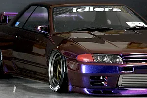 Close-up of a custom painted purple and brown Nissan Skyline GT-R RC drift car body shell with deep dish wheels.