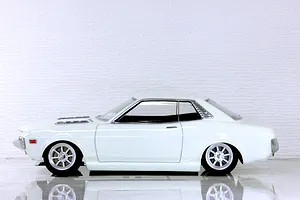 Side profile of a white Toyota Celica 1600GT RC drift and touring car body shell mounted on a chassis with custom wheels.