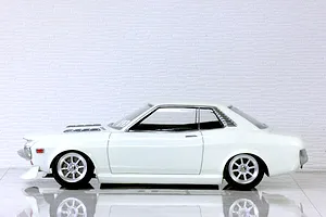 Side profile view of a white Toyota Celica 1600GT RC drift and touring car body shell mounted on a chassis with custom wheels.