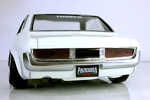 Rear view of the white Pandora RC Toyota Celica 1600GT body shell, showing taillights, chrome bumper, and Pandora RC license plate.