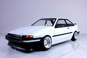 A painted white Pandora RC Toyota AE86 Sprinter Trueno 2-door body shell mounted on a chassis with custom wheels against a neutral studio background.