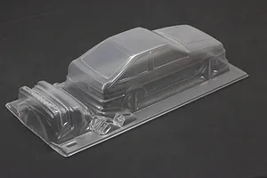 Unpainted clear polycarbonate RC car body shell for a Toyota AE86 Corolla Levin on a dark surface.