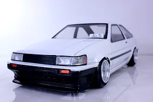 White Pandora RC Toyota AE86 Corolla Levin 3-door drift body shell on a reflective surface.