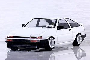 Front three-quarter view of a painted white Toyota AE86 Sprinter Trueno 3-door RC body shell on a reflective surface.