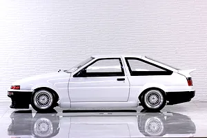 Side profile of a white Pandora RC Toyota AE86 Sprinter Trueno 3-door body shell mounted on an RC chassis with mesh wheels.