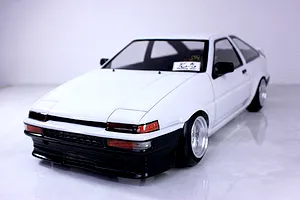 A painted white and black Pandora RC Toyota AE86 Sprinter Trueno 3-door body shell mounted on an RC chassis.