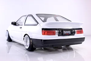 Rear three-quarter view of a white Pandora RC Toyota AE86 Sprinter Trueno 3-door body shell on a reflective white studio background.