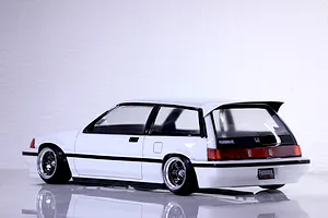 Rear three-quarter view of a painted white Honda Civic Si RC drift car body shell with black trim and custom wheels.